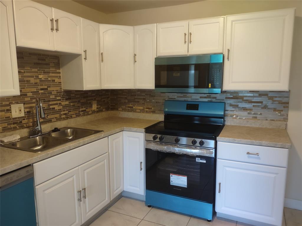 128 Miami Gardens Road West Park, FL 33023 - Photo 9 of 38 a kitchen with a stove and a microwave