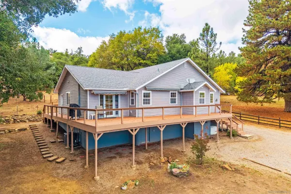 a aerial view of a house with a yard table and chairs