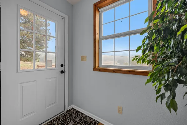 a work room with furniture a rug and a window