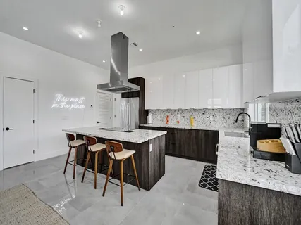 a kitchen with a stove a refrigerator and a dining table