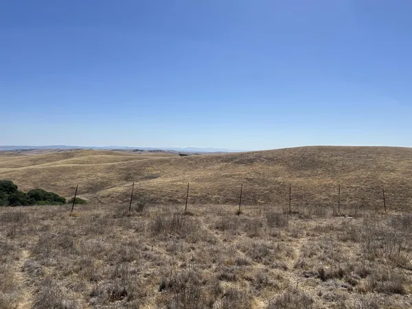 a view of ocean and green field
