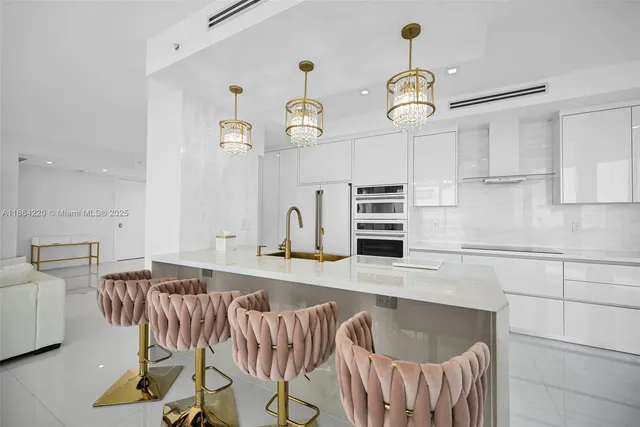 a kitchen with granite countertop a table chairs stove and white cabinets