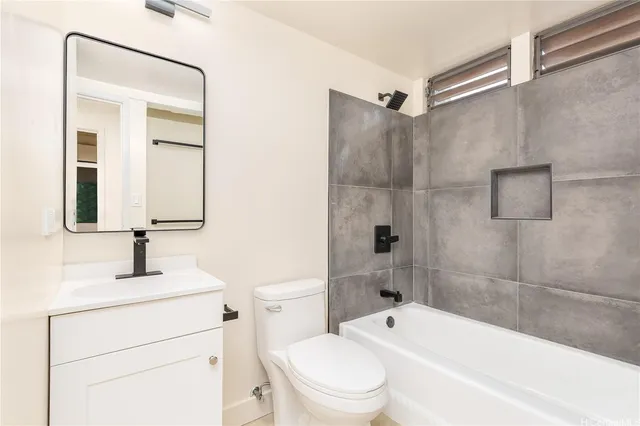 a bathroom with a bathtub shower sink vanity and toilet