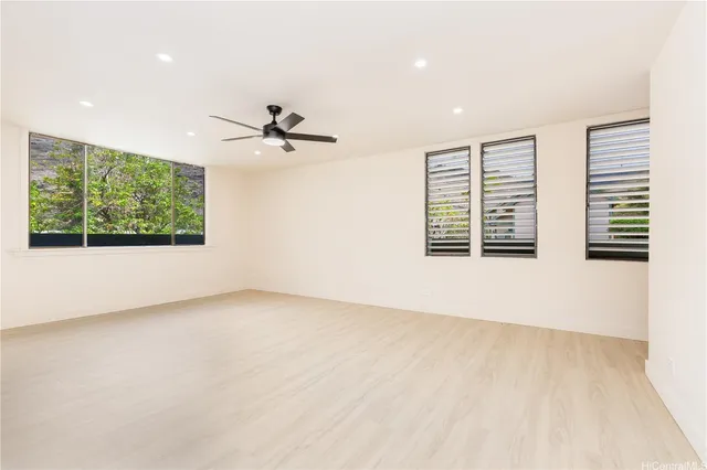 an empty room with windows and ceiling fan