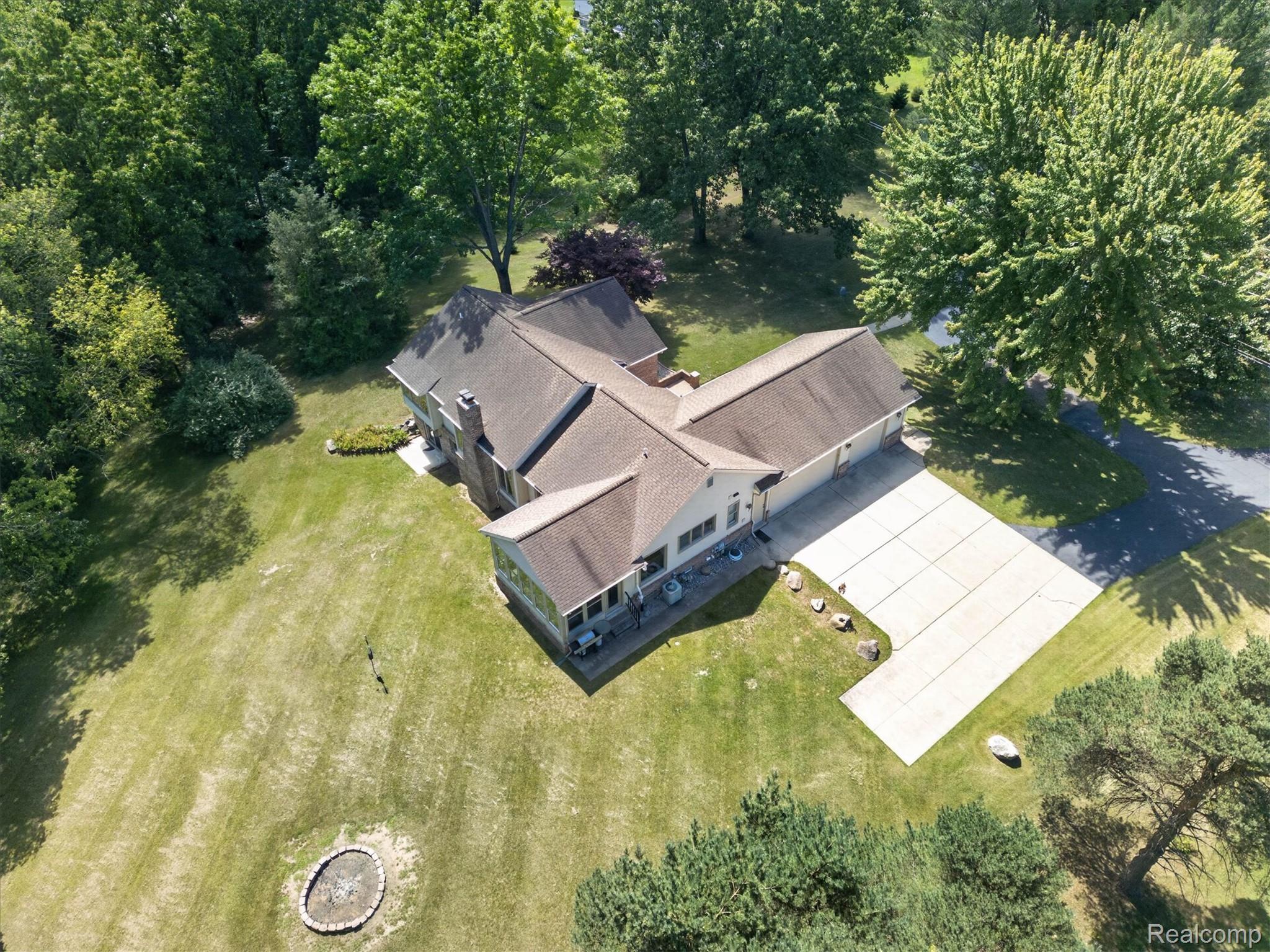 4037 Chilson Road Howell, MI 48843 - Photo 57 of 69 Expansive lot featuring a large residence with a multi-gabled roof, attached garage, and a concrete paver patio