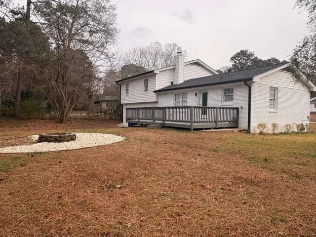 a view of a house with a yard and fence