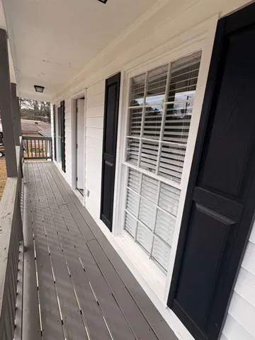 a view of kitchen and empty room with wooden floor
