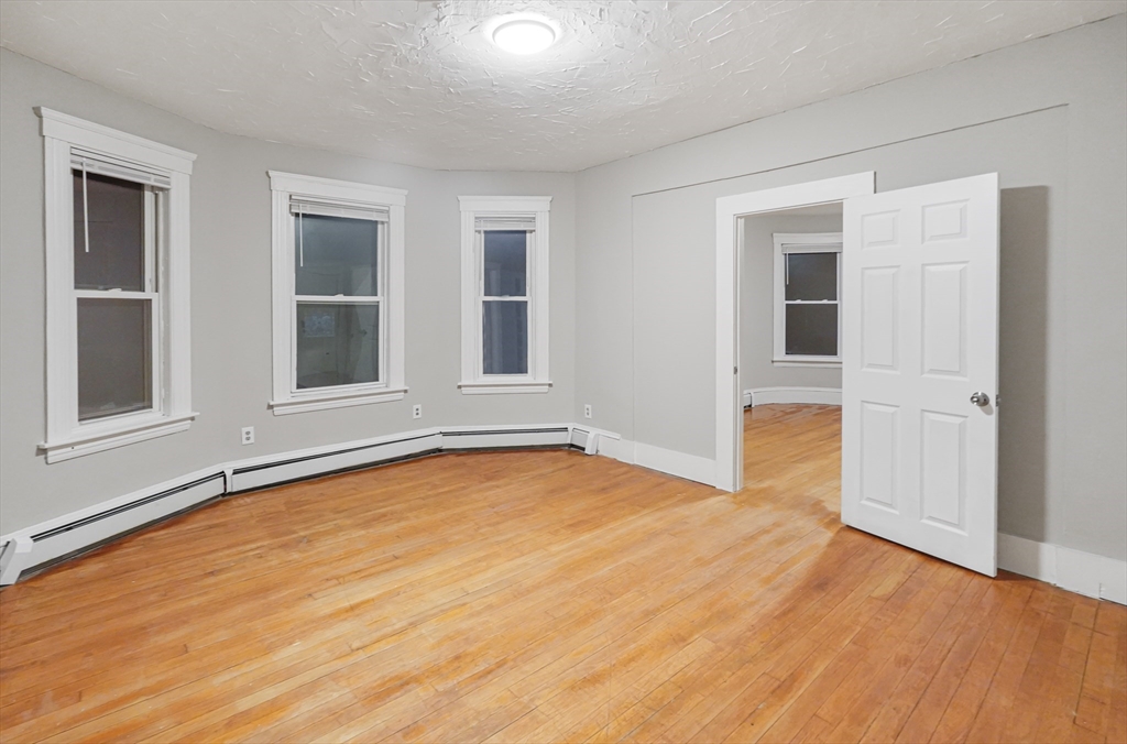 15 Mendon Street, Unit 3 Worcester, MA 01604 - Photo 2 of 28 a view of an empty room with wooden floor and windows