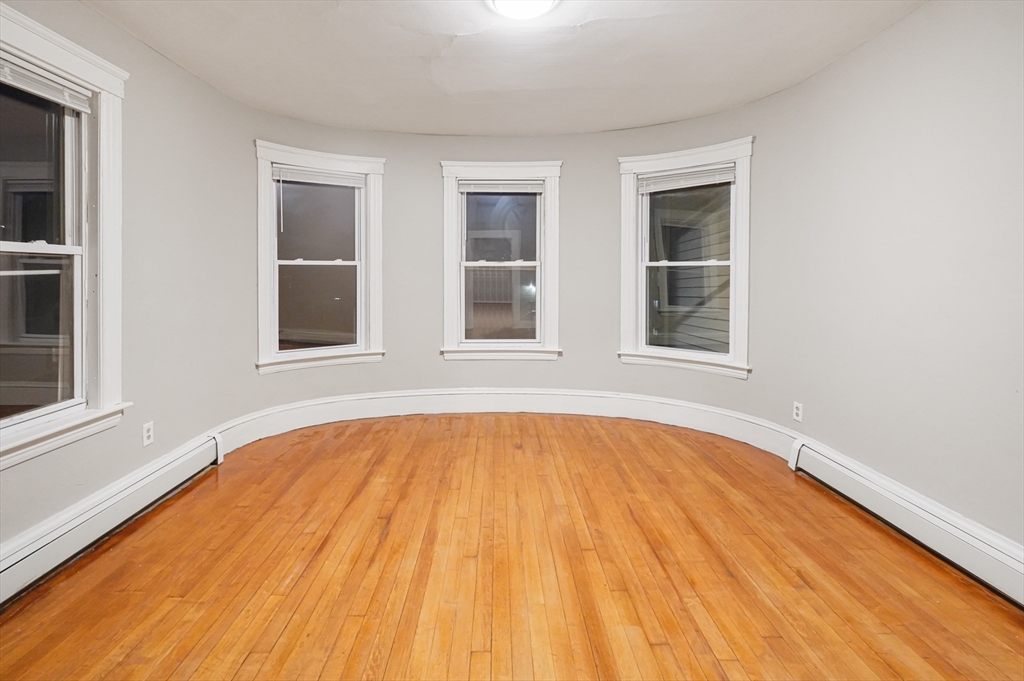 15 Mendon Street, Unit 3 Worcester, MA 01604 - Photo 5 of 28 a view of an empty room with a window and wooden floor