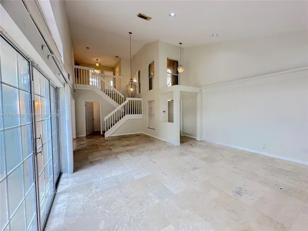 a view of a hallway to a room with wooden floor