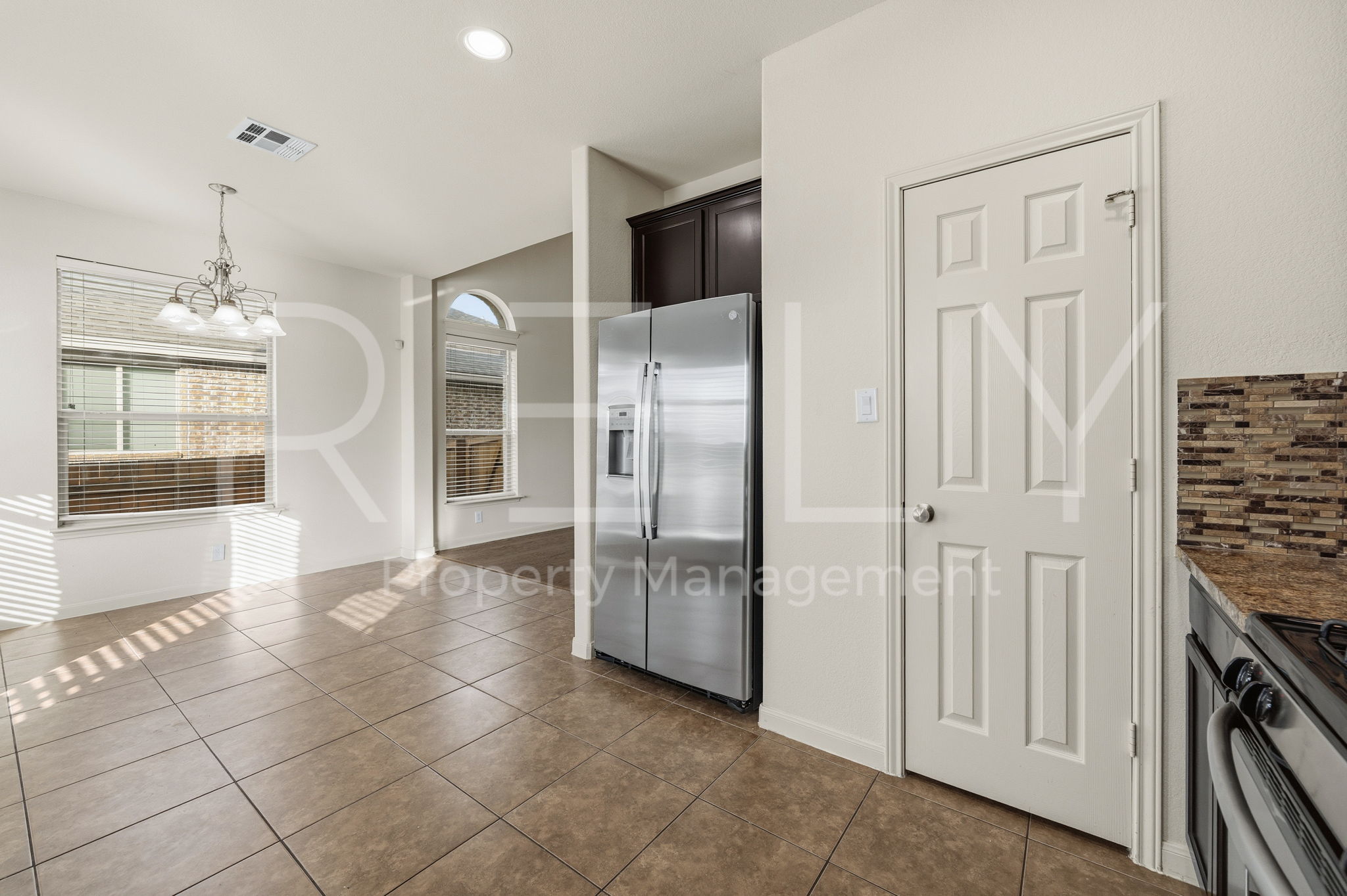 1405 Sunny Meadows Loop Georgetown, TX 78626 - Photo 11 of 40 A well-lit kitchen and dining area features tile flooring and stainless steel appliances, creating an inviting space.