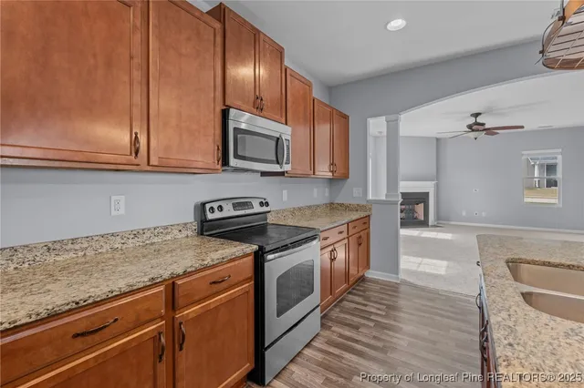 a kitchen with stainless steel appliances granite countertop a stove a sink and a microwave