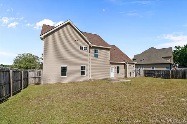 a front view of house with yard and trees in the background