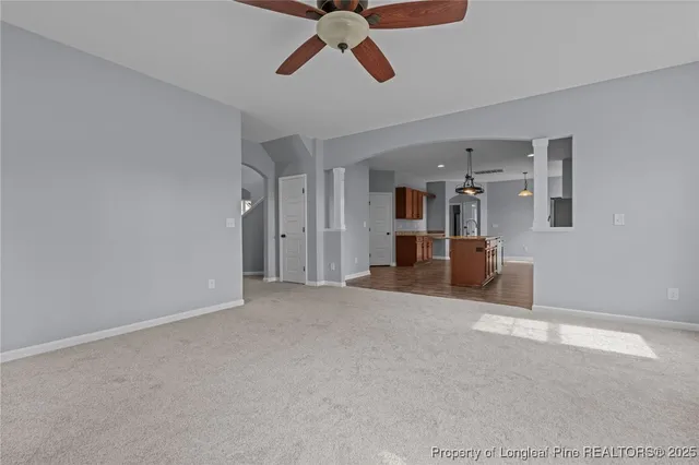 a view of a livingroom with a ceiling fan and window