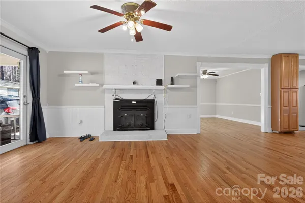 a view of empty room with wooden floor and fireplace