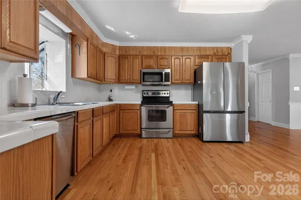 a kitchen with stainless steel appliances granite countertop a refrigerator stove and sink
