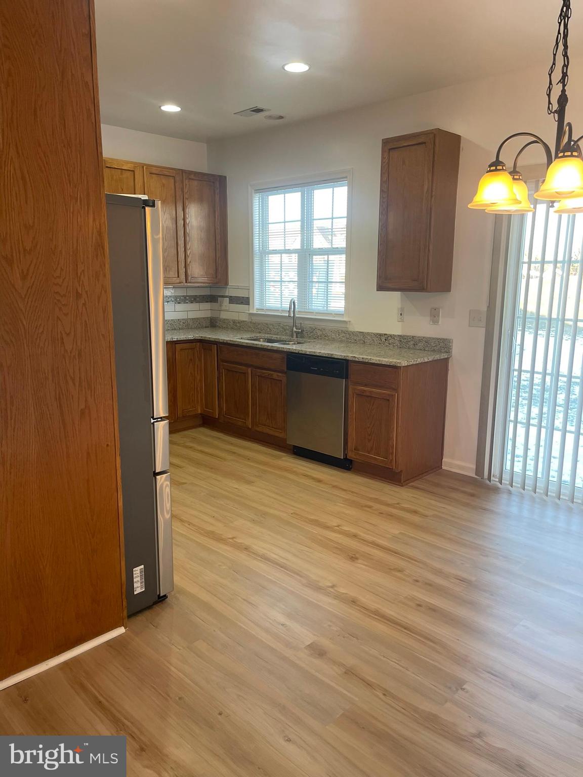 62 Springfield Circle Middletown, DE 19709 - Photo 15 of 37 a kitchen with stainless steel appliances granite countertop a refrigerator a sink dishwasher a stove and white countertops with wooden floor