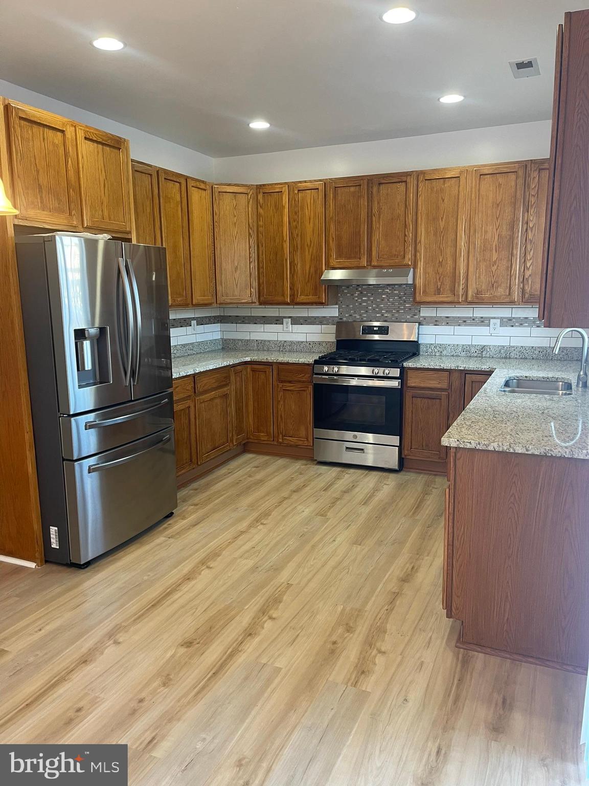 62 Springfield Circle Middletown, DE 19709 - Photo 16 of 37 a kitchen with granite countertop a refrigerator and wooden cabinets