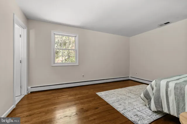 a view of a room with wooden floor and a window