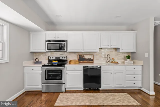 a kitchen with cabinets stainless steel appliances and a sink