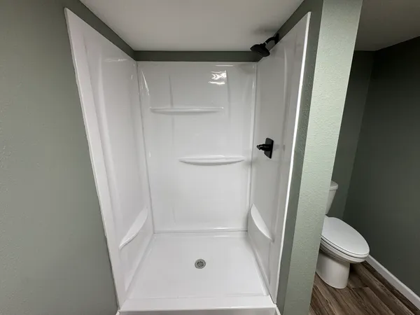 a bed sitting in a bedroom with wooden floor