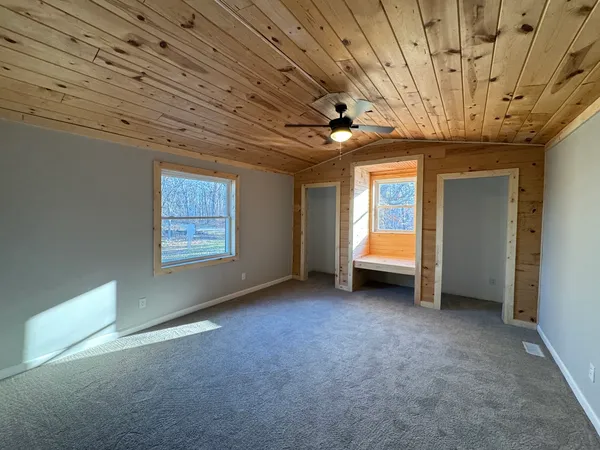 a view of an empty room with window and fire place