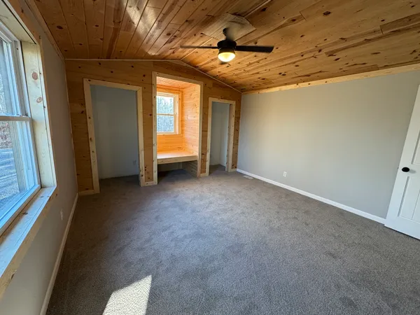 an empty room with closet and windows