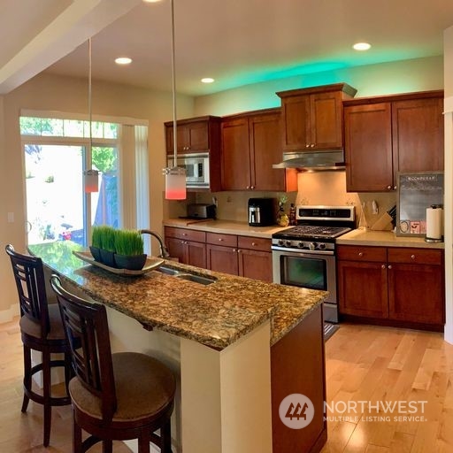23029 35th Drive Southeast Bothell, WA 98021 - Photo 11 of 40 a kitchen with stainless steel appliances kitchen island granite countertop a stove a sink and a refrigerator