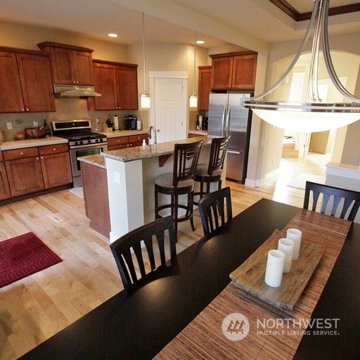 23029 35th Drive Southeast Bothell, WA 98021 - Photo 14 of 40 a kitchen with stainless steel appliances granite countertop a stove a sink a dining table and chairs