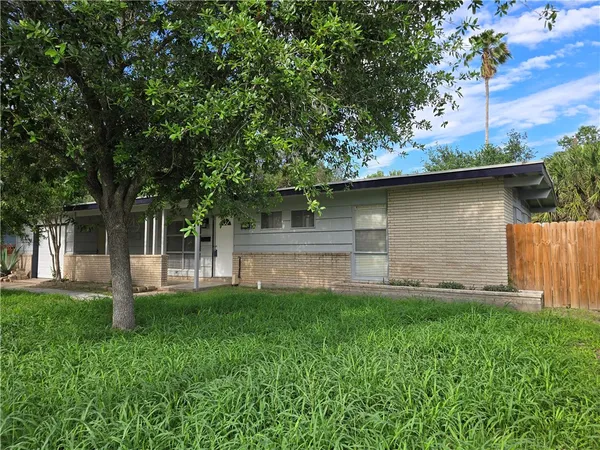 a front view of house with yard and trees