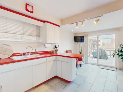 a utility room with stainless steel appliances granite countertop a sink and cabinets