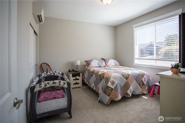 a bedroom with bed and a bed next to a window