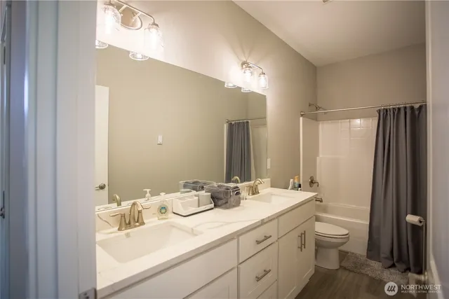 a bathroom with a double vanity sink and a mirror