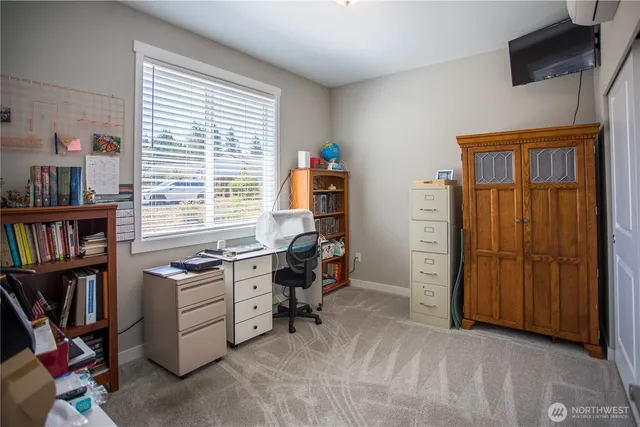 a view of a workspace with furniture and a window