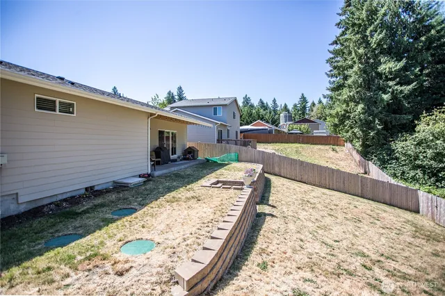 a view of a house with backyard and trees