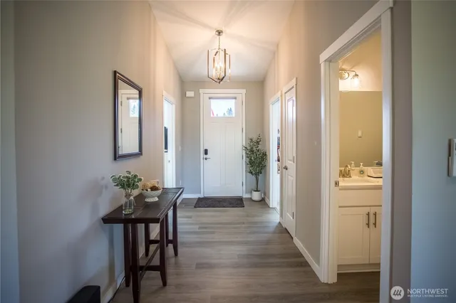 a view of a hallway with wooden floor windows and a bathroom