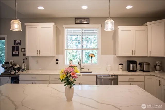 a kitchen with a white cabinets and chandelier
