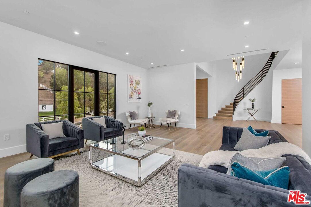 24961 Kit Carson Road Hidden Hills, CA 91302 - Photo 12 of 53 a living room with furniture and large windows