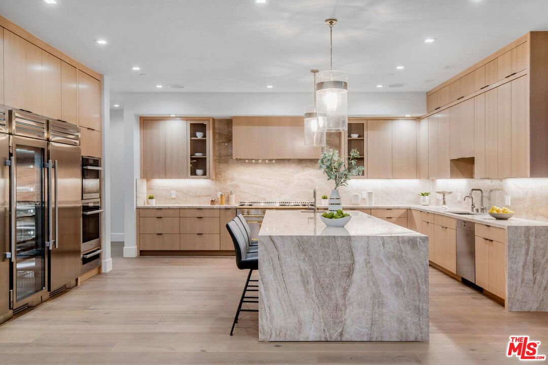 24961 Kit Carson Road Hidden Hills, CA 91302 - Photo 16 of 53 a kitchen with stainless steel appliances kitchen island granite countertop a sink refrigerator and cabinets