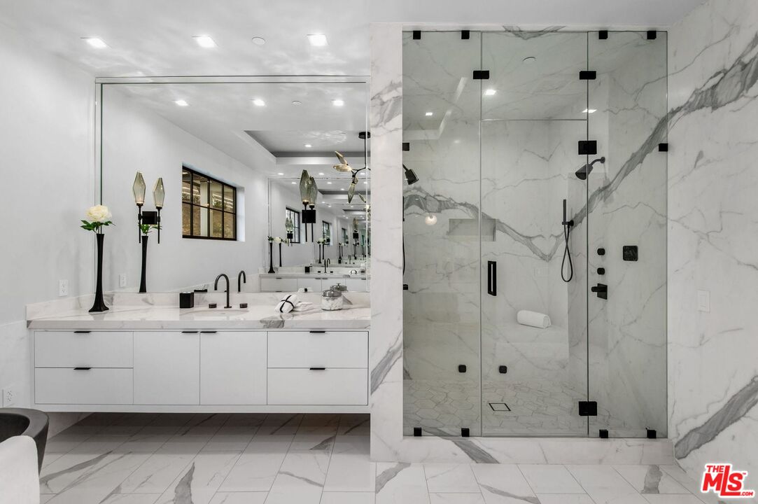24961 Kit Carson Road Hidden Hills, CA 91302 - Photo 26 of 53 a bathroom with a double vanity sink mirror and shower