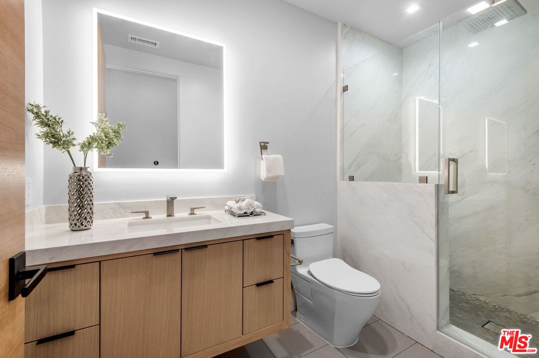 24961 Kit Carson Road Hidden Hills, CA 91302 - Photo 42 of 53 a white toilet sitting next to a bathroom sink