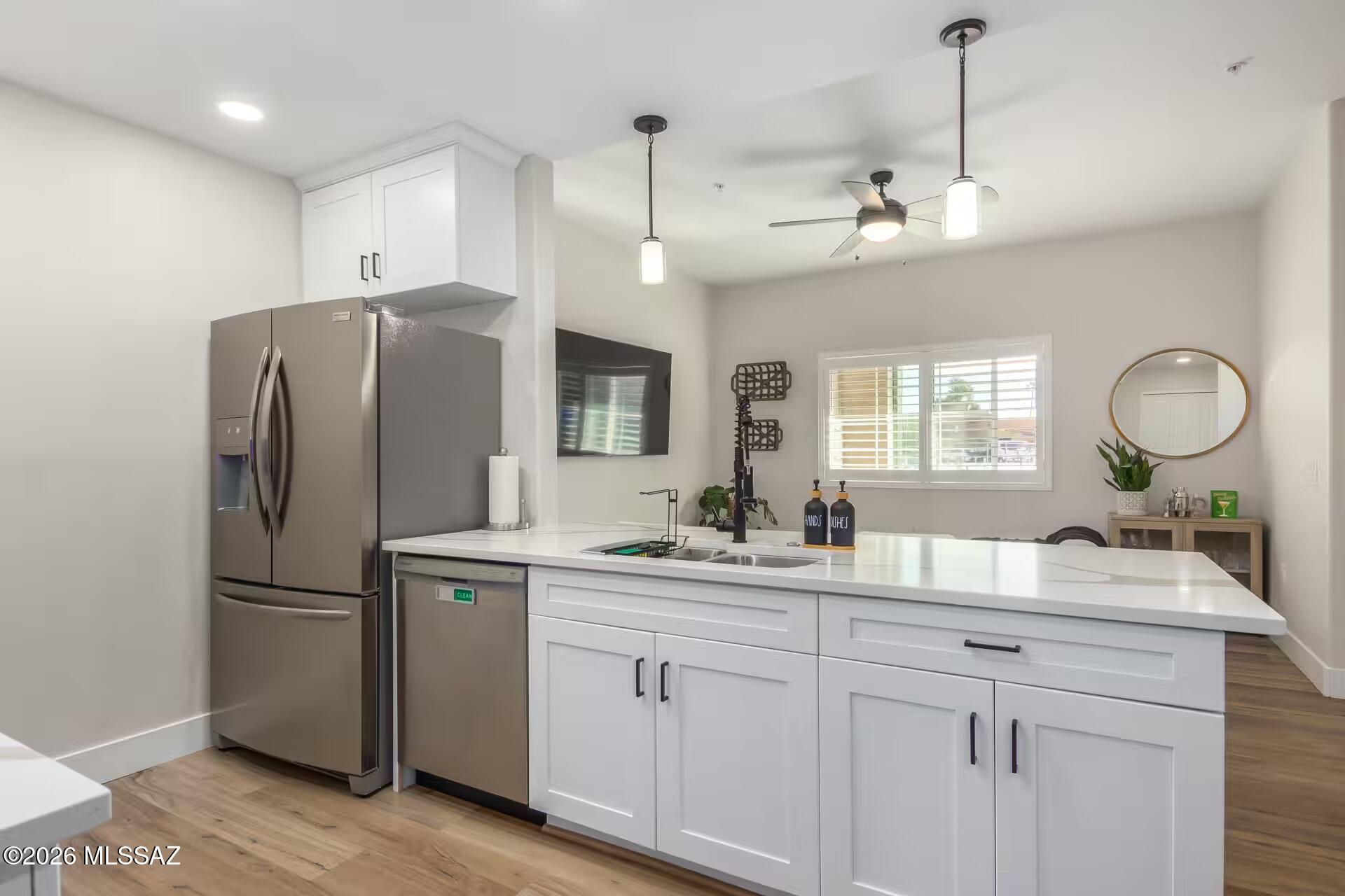 2036 East River Road, Unit 104 Tucson, AZ 85718 - Photo 6 of 23 a kitchen with kitchen island white cabinets and refrigerator