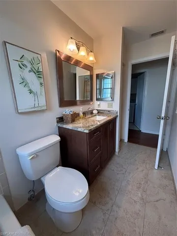 a spacious bathroom with a granite countertop sink and a mirror