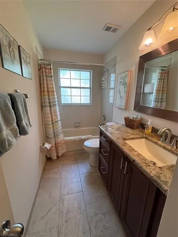 a bedroom with two beds and painting on the wall