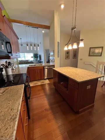 a large kitchen with kitchen island a stove a sink a center island and cabinets