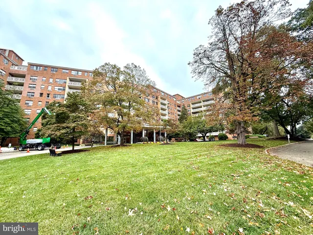 a view of a house with a big yard and large trees