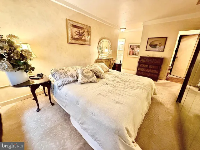 a bedroom with a bed and a lamp on dresser