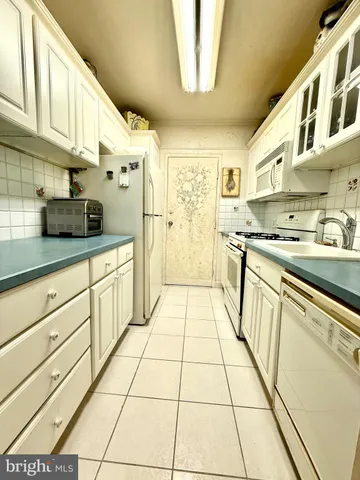 a kitchen with stainless steel appliances a sink a stove a refrigerator and cabinets