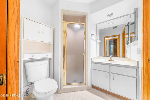 a bathroom with a toilet sink vanity and mirror