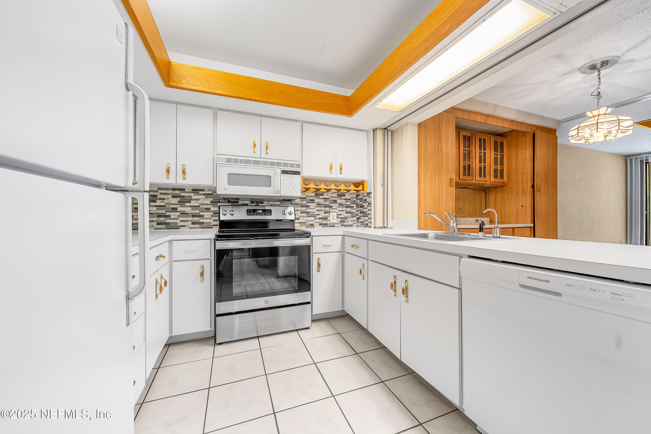 2930 Ravines Road, Unit 1226 Middleburg, FL 32068 - Photo 4 of 30 a kitchen with a stove a sink and a microwave